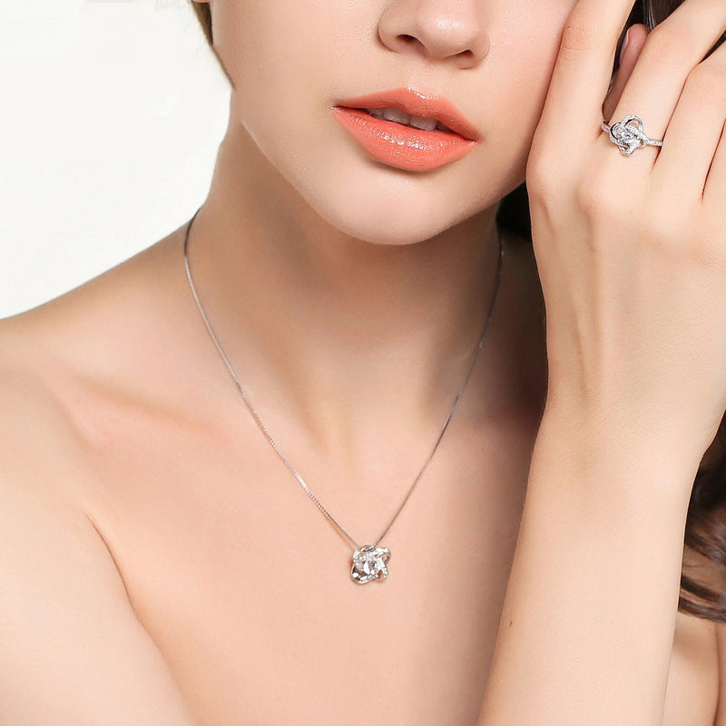 Woman wearing a silver necklace and ring on a white background