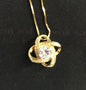 Gold necklace with a diamond pendant on a black background